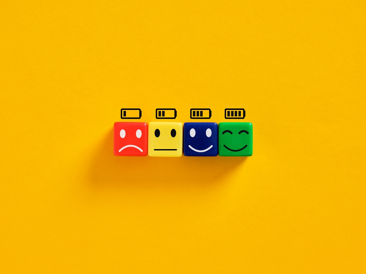 A row of plastic cubes paired with illustrated battery indicators depicting different states of mental energy